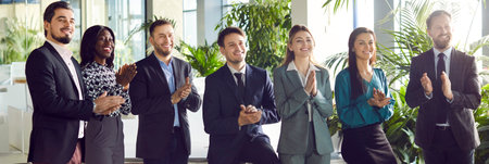 Diverse businesspeople applaud at an office event, celebrating the success of teamwork. The meeting...