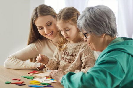 Side view of three generations of women enjoying time together, playing with colorful shapes....