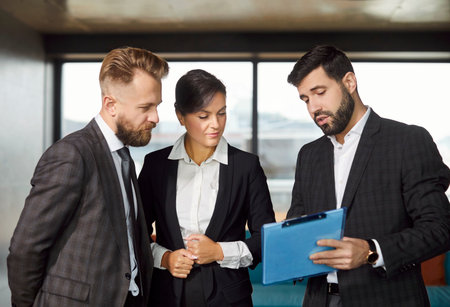 Business people discussion, standing in modern office hall, motivated team, real estate agent, mortgage or rent documents, businesspeople presenting, discussing project details, research resultsの写真素材