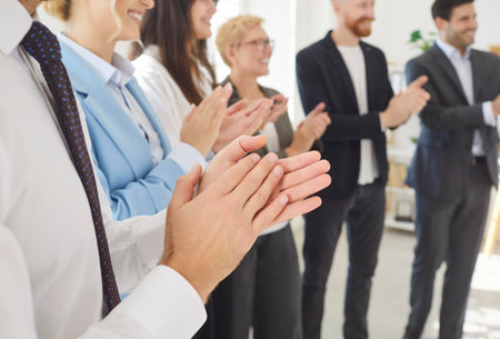 Applauding employees happy clapping hands in office, workers cheering, standing in modern office at...