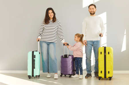 Family traveller tourist, parents, daughter child standing near wheel bright suitcases, ready for summer trip holiday, luggage bag vacation travel, clothes into suitcase journey, planning relocationの写真素材