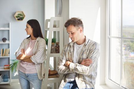 Sad married couple experiences conflict and sadness at home. The confrontation and quarrel hint at...