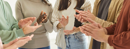 Friends clapping hands in circle close up, greeting, group meeting, grateful audience applauding thanking coach for presentation or seminar, successful team after accomplishing desired aim or resultの写真素材