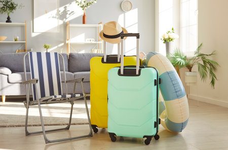 Happy summer vacation preparation, luggages, beach chair, inflatable summer rubber ring, sun hat, traveling leisure dream holiday, recreation, cool pleasure, happy activity rest, relaxation tourismの写真素材