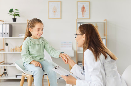 Caring pediatrician kind doctor meets child, examination, female medical practitioner consulting small girl for preventing, diagnosing, general practitioner treating teen diseases in clinic, hospitalの写真素材