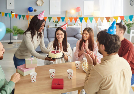 Group of happy women and men friends having party and celebrating birthday, have good festive mood....