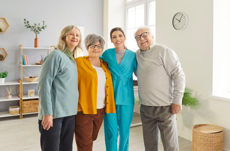 Group of positive senior people posing together with nurse, being happy with care provided to them...