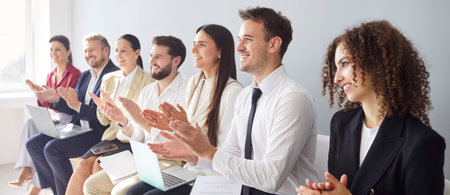Young business people in formal clothes applauding to speaker sitting in a row in meeting room on gray background. Smiling company employees clapping on business training or conference. Bannerの写真素材
