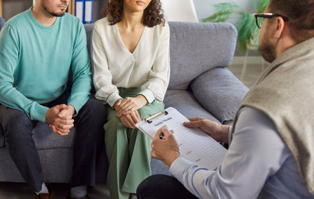 Close up shot of a psychologist holding therapy session for family couple, offering support, help, and assistance through consulting and talking in a professional setting with focus and care.の写真素材