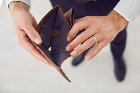 Close up of poor unrecognizable unemployed business man hands holding and opening empty wallet isolated on white background. Bankrupt, no money, financial crisis and cost control conceptの写真素材