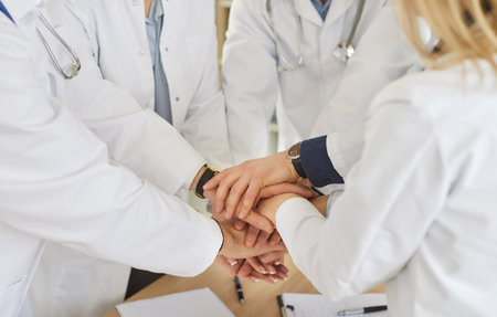 Medical doctor team staff common high five together, corporate clinic workers join hands in success gesture, startup triumph, professional victory, teamwork accomplishment teambuilding close upの写真素材