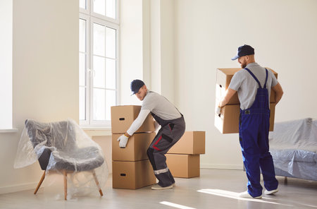 Delivery service men carrying, shipping specialists for transporting, cardboard boxes, movers service unloading and removing things for moving company working, helping to change residence packingの写真素材
