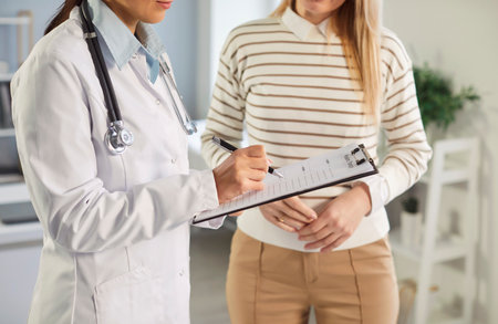 Consulting, making notes, results checking in feminist health clinic, supporting caring female doctor meeting, greeting, consulting young woman patient, offering medical advice in gynecologyの写真素材