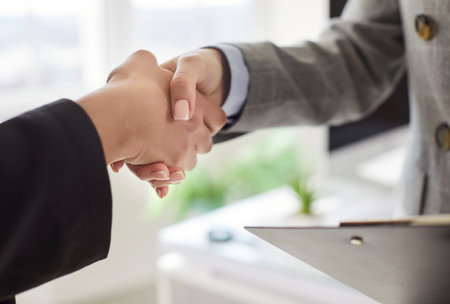 Close-up of business people or coworkers shaking hands in office, sealing deal with partnership and...