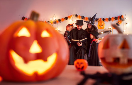 Happy Halloween pumpkin smiling carved lantern decor, family party fun gather at home wearing cosplay costume amuse, scary people in black, festival amuse, spooky gothic Masquerade ball eventの写真素材