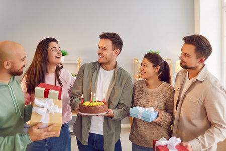 Happy birthday candle cake, presents celebration, friendly group family portrait, young friends party together for special event. Smiling people gathering making fun and enjoy wishing great happinessの写真素材