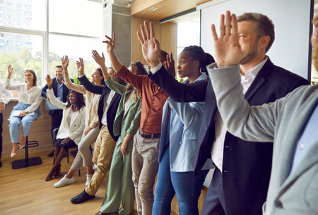 Diverse audience voting or asking questions at a business conference or other public event. Group of...