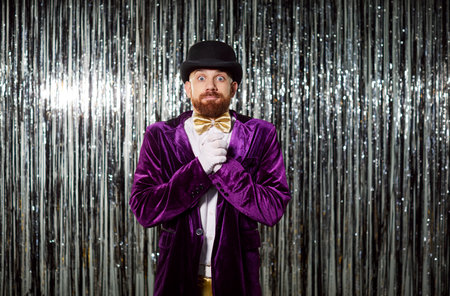 Portrait of an amazed and surprised man in a purple costume on a shiny background during a party. Festive celebration includes fun entertainment, expressive emotions, and a vibrant evening atmosphere.の写真素材