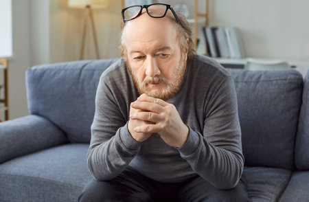 Sad thoughtful bored older man alone looking feeling depressed, frustrated, lonely, suffering form memory loss, dementia, Alzheimer disease, mental disorder, having old age problem, missing familyの写真素材