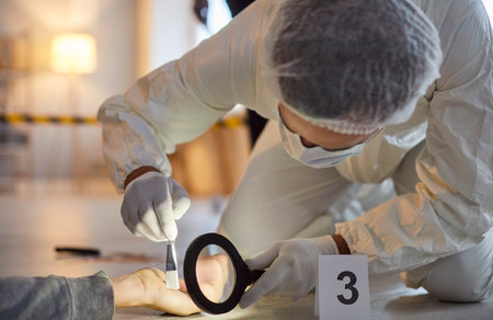 CSI criminalist examining a crime scene, using a magnifier to collect evidence from a dead body. Forensic investigation supported by police and 911, ensuring justice and case resolution.の写真素材