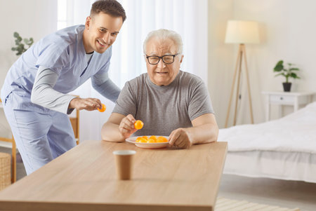 Senior nursing help, health care of elderly people, young geriatric nurse helping old man, healthcare professional man caring, playing game laughing for joy, enjoying leisure funの写真素材