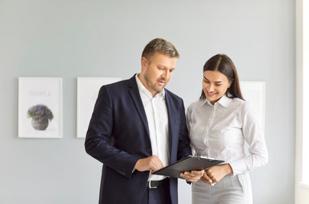 Businessman or real estate agent consulting a customer on the purchase or rental of a home or property. The consultation emphasizes the realtor expertise in guiding property ownership decisions.の写真素材