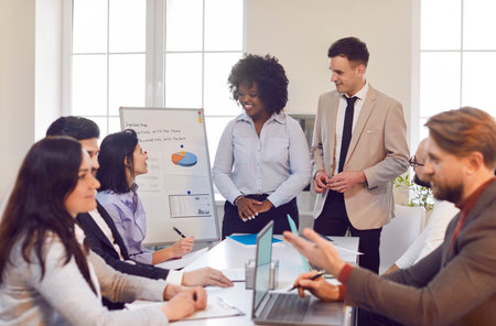 Team of business people gathers in the office for a work meeting or conference. The event focuses on teamwork, collaboration, successful business strategies and colleague interactions.の写真素材
