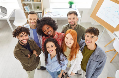 Happy group of multinational professional business people standing together in an office, smiling for a portrait. The team represents diverse professionals working in a business environment.の写真素材