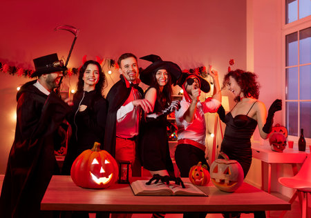 Portrait of a crowd of friends celebrating a halloween party together at home in costumes. Fun holiday gathering features themed outfits, decorations, and a joyful festive atmosphere.の写真素材