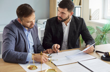 Lawyers at desk consulting, discussing to advise and represent client in criminal or civil proceeding, legal matter, professional solicitor or barrister, attorney performs legal tasks to prepare casesの写真素材