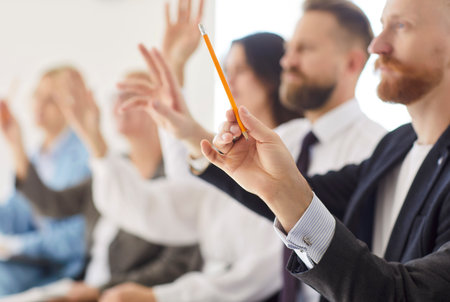 Office employee group close up voting, educational seminar participants raise hands to ask question during meeting or briefing, interview or workshop, opinion, hr members choosing candidatesの写真素材