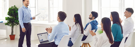 Business coach giving presentation for new company staff, group of professionals gathered in conference room engaged in educational briefing, formal meeting event, seminar training, brainstorm ideasの写真素材