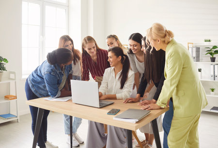 Young diverse female business people discussing job project or new startup with brainstorming sitting at the desk in office. Women working on a meeting with laptop together. Teamwork concept.の写真素材