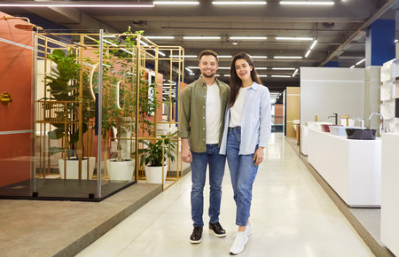 Portrait of a happy and smiling family couple browse a bathroom hardware store. Excitement about making a purchase is evident as they explore plumbing options for home renovation project in the shop.の写真素材