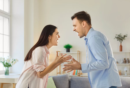 Couple woman and man arguing and shouting at each other, have quarrel and problems in relationship, want to divorce, gesturing angrily, having misunderstanding. Family quarreling conceptの写真素材