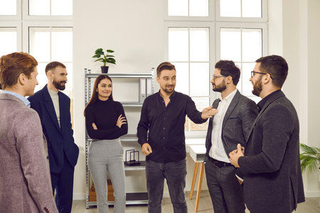 Cheerful business colleagues communicating during meeting in office. Group of confident successful business people, coworkers in formal wear talking to each other, discussing new projectの写真素材