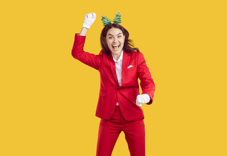 Overjoyed woman dancing carefree, enjoying Christmas holidays, having fun on New Year costume party, isolated over vivid yellow background. People and holiday conceptの写真素材