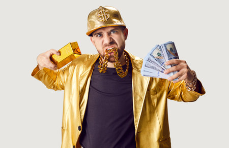 Cute happy rich guy with money, golden bullion, wearing gold necklace and golden bright jacket posing, wealthy popular producer, trendy, stylish casting director, fancy celebrity, bright disco outfitの写真素材