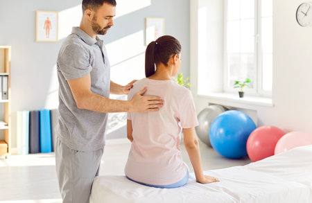 Male physiotherapist and masseur provides back massage therapy to a patient in a rehabilitation clinic. Physical therapy promote healing and relief tension through rehabilitation techniques.の写真素材