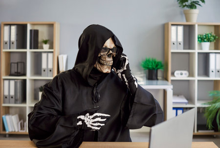 Grim reaper as skeleton engages in phone conversation in office, negotiation and talking during call, blending online communication with a haunting presence in a stark business space.の写真素材
