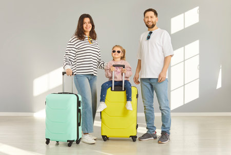 Happy vacation family, tourists planning holiday summer trip with luggage ready for flight, dreaming of aircraft journey, travelling, emigration, packed large suitcase bag, relocation destinationの写真素材