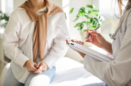 Close-up of a female doctor or nurse hands holding a tablet during a hospital examination and conversation. The medical consultation highlights healthcare treatment and essential patient care.の写真素材