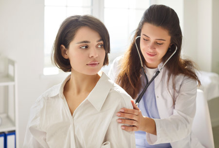 Doctor with stethoscope listening back to heart, lungs, female health care, clinic checking up exam, patient healthcare in hospital for professional controlling physical well-being, consultingの写真素材