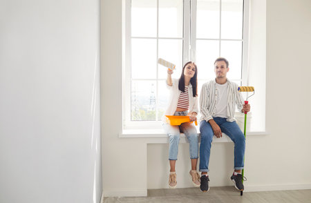 Positive and happy family couple dreaming together while renovating and painting new home. Embrace creative ideas, planning construction and personalizing space during the building process.の写真素材