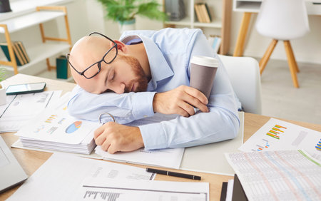 Tired businessman sleeping at table, surrounded by documents, symbolizing office burnout. Overworked...