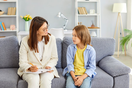 Child psychologist professional comforting asking teen boy, speaking, giving sympathy, advice, giving health, academics, social support, teenager and mentor teacher worker kind personal talkの写真素材