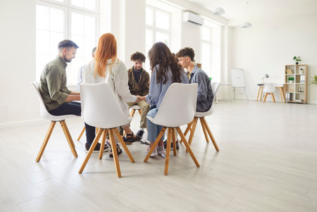 Psychological support meeting, business group counselor, therapist coach psychologist speaking counseling on therapy session to support patients in addiction talk, share problem sitting in circleの写真素材