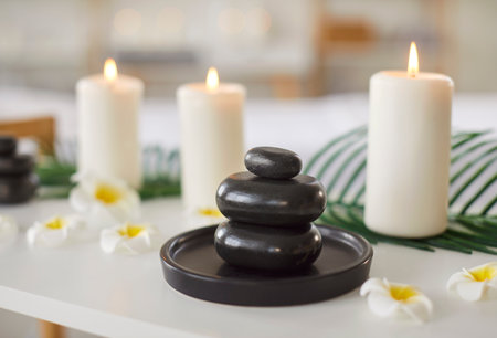 Cosmetology spa salon room desk with massage hot stones, aromatherapy candles, welcoming atmosphere for female clients, medical care, offering health, asian flower beauty, aromatherapy therapistの写真素材