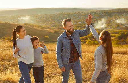Happy friendly family nature outdoor trip, high five gesture, spending weekend holiday together, parent, children enjoy time, celebrate vacation, resting recreation activity, having close relationshipの写真素材