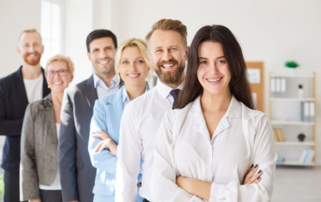 Smiling supportive diverse businesspeople team standing, confident excited male, female employees happy with job promotion or hr success, colleagues enjoy work achievement, welcoming new memberの写真素材
